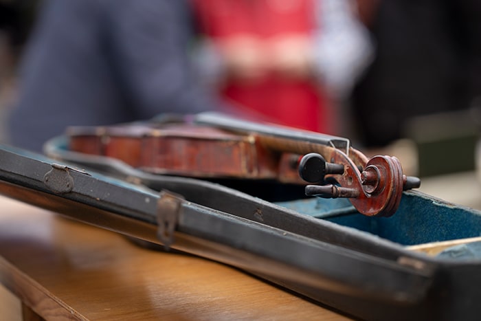 An open instrument case with a violin lying inside it