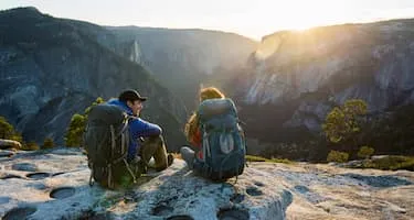 young hiking couple sitting in yosemite national park