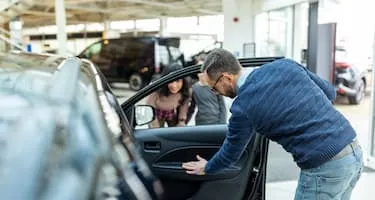 Man checks interior of car before buying