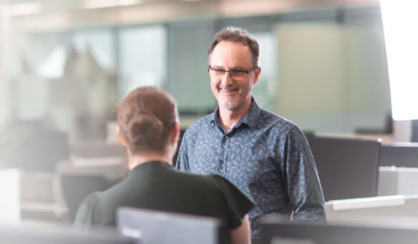 Colleagues holding casual conversation in office