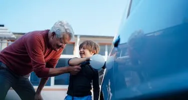 Grandfather and grandson charge electric car