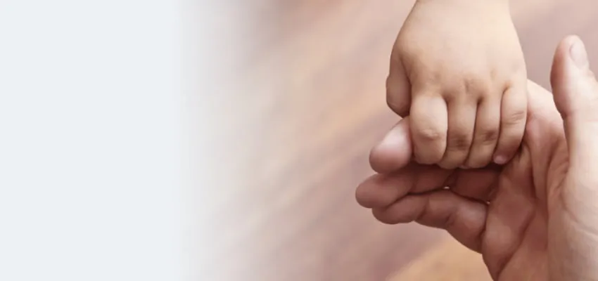 Child hand holding the fingers of an adult