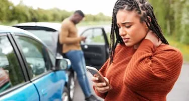 Female motorist calls her insurer after a car accident