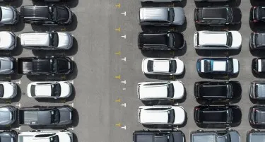 Aerial view of carpark filled with black and white cars.
