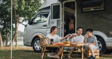 Young family has a picnic outside their caravan