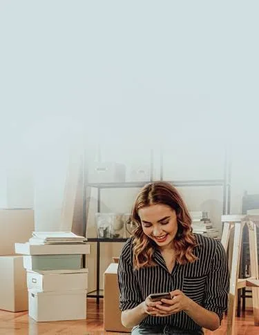 Woman looking on her phone, happy that her rental application was approved.