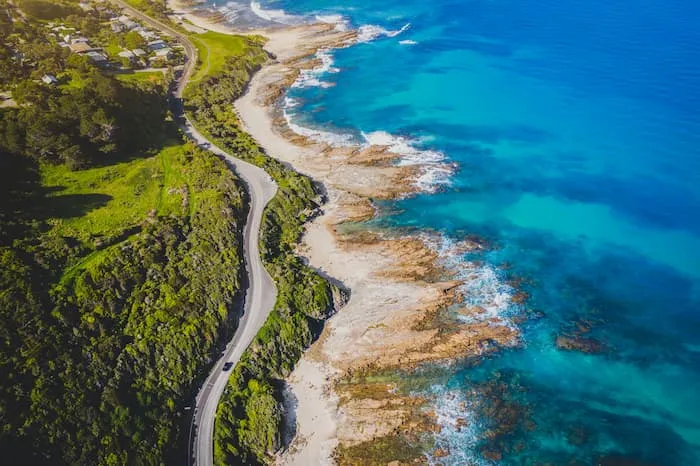 The Great Ocean Road with the coastline on one side and beach on the other.