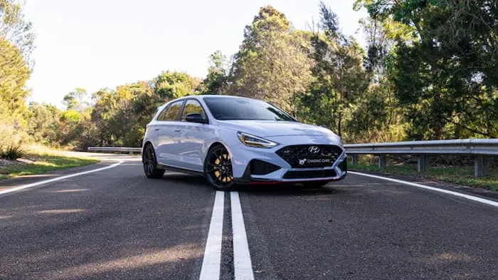White Hyundai i30N parked across white lines on road