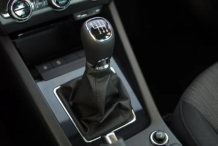 A black manual gear stick displays white letters and numbers for when drivers need to reverse and move into different gears.