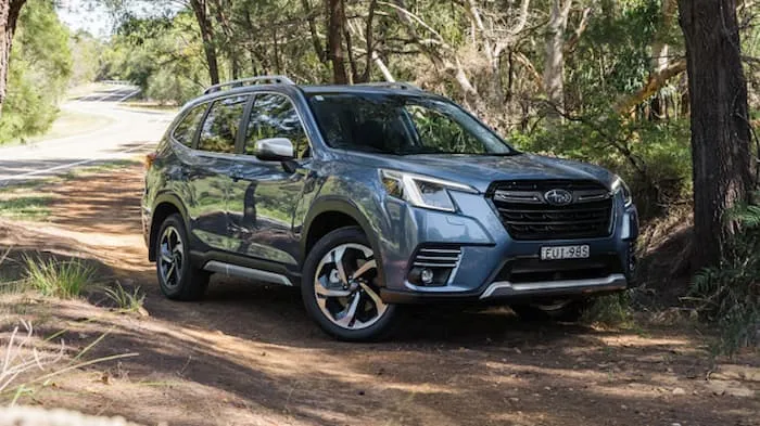 Blue subaru forester parked on dirt path in bush