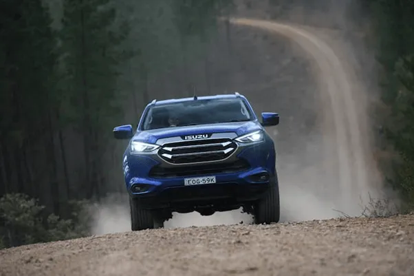 blue isuzu MU-X driving outside along dirt road