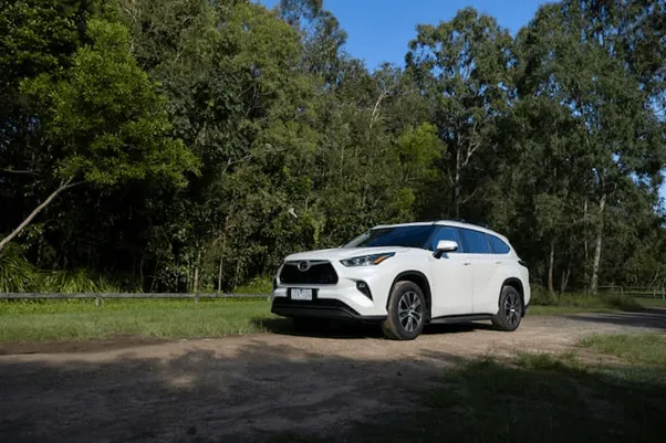 white toyota kluger parked outside on gravel