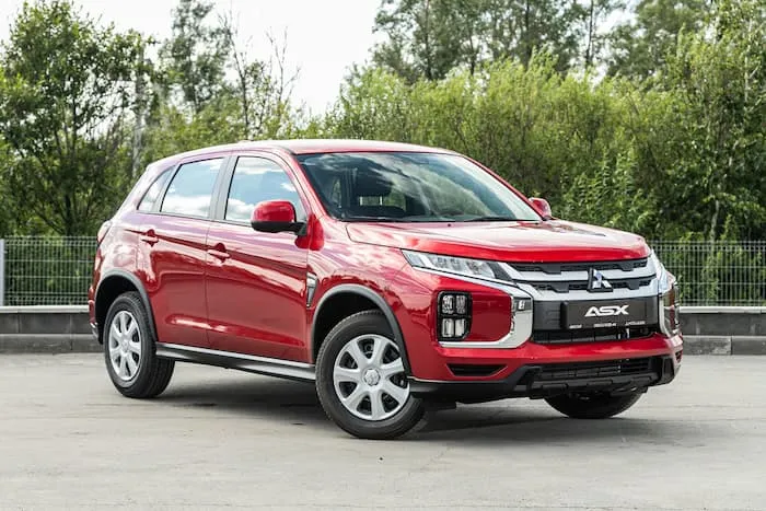 red Mitsubishi ASX parked on road outside