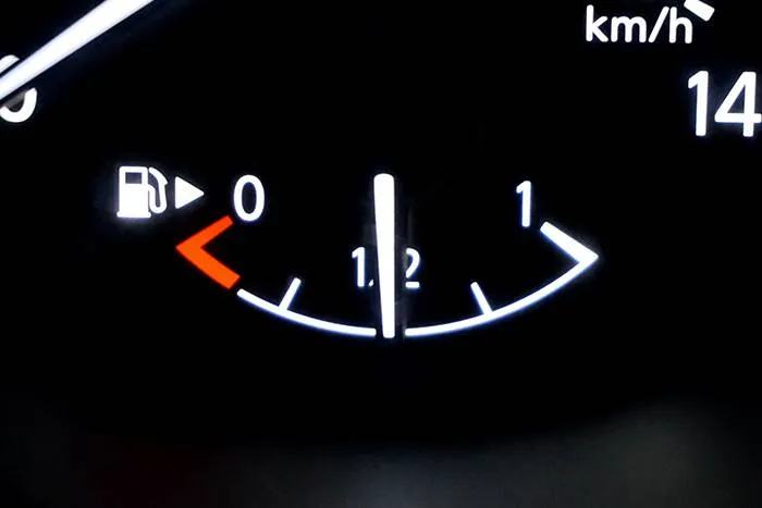 Car fuel gauge showing half-empty tank.
