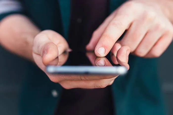 Close-up of hands texting on a smartphone