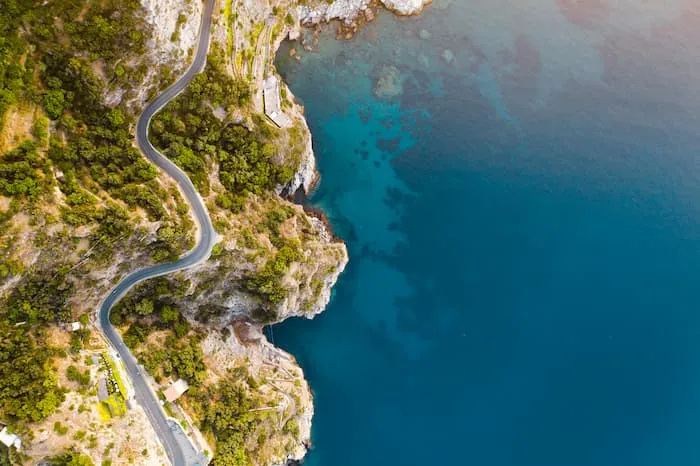 The Amalfi Coast Road winds through shrubbery on the Italian coast.