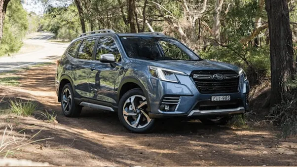 silver Subaru Forester driving outside along road