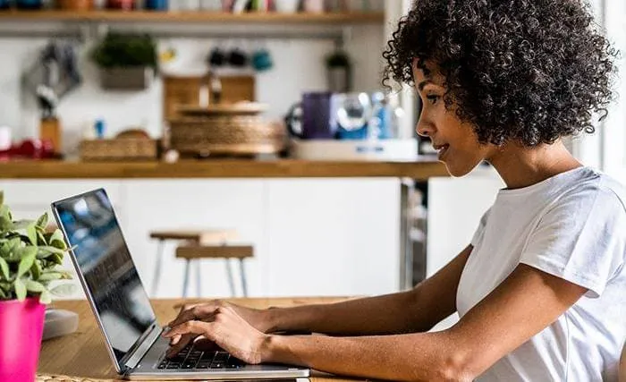 Woman sitting at table and working on laptop