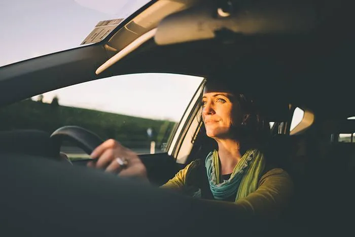 Woman driving into the sunset