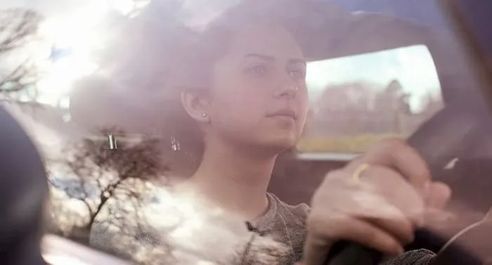 Young woman in driver's seat of car