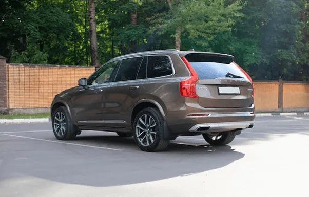 brown Volvo XC90 Recharge parked outside in carpark