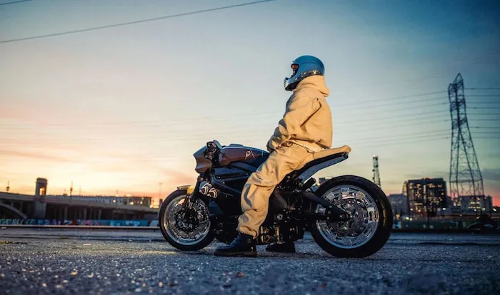 Man sits on a Livewire electric motorcycle in an empty carpark at dusk.