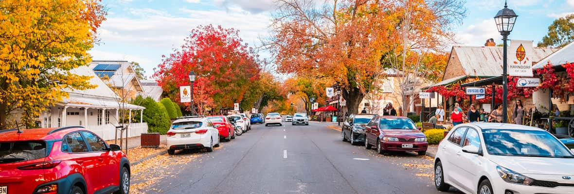 Cars line a quaint street during autumn time in the town of Hahndorf, South Australia.