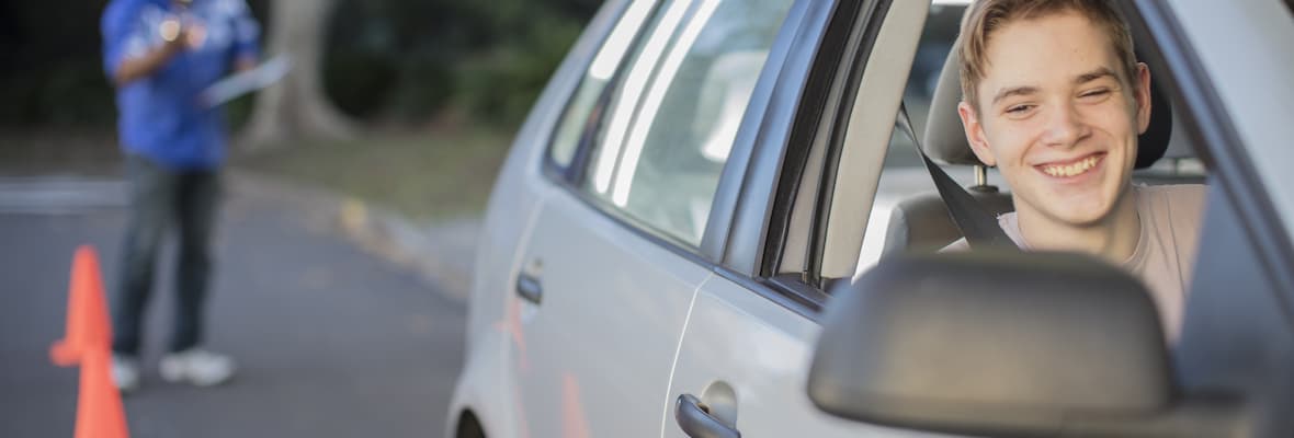 Young man checks his car mirrors during a driving test