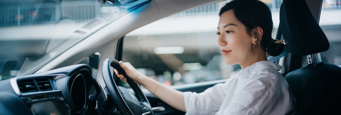 Young woman sits in the driver's seat before driving