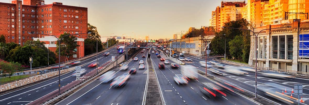 Cars driving on busy Sydney road at sunset
