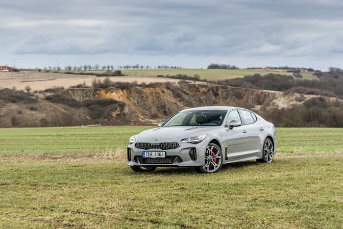 silver Kia Stinger parked on grass outside