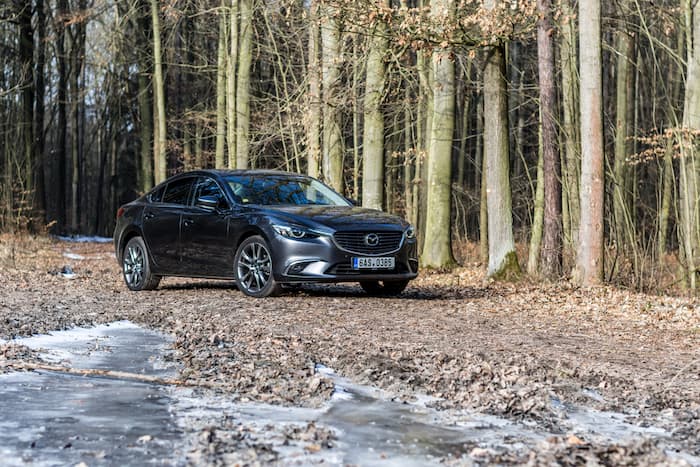 black Mazda 6 parked in forest outside