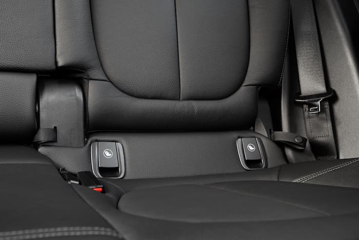 Low ISOFIX anchor points and a seatbelt sit inside a modern car