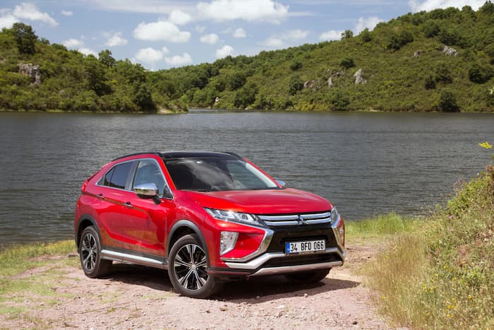 Red Mitsubishi Eclipse Cross pared in front of lake