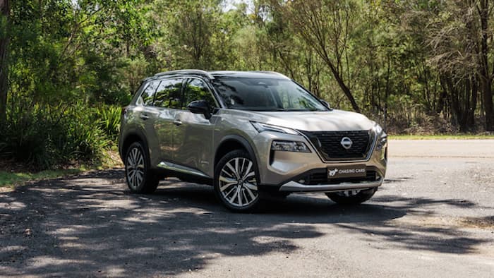 Nissan X-Trail E-Power is parked off road near green shrubery