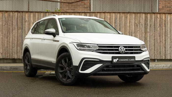 White Volkswagen Tiguan Allspace 110TSI Life 2022 is parked in front of a brown fence