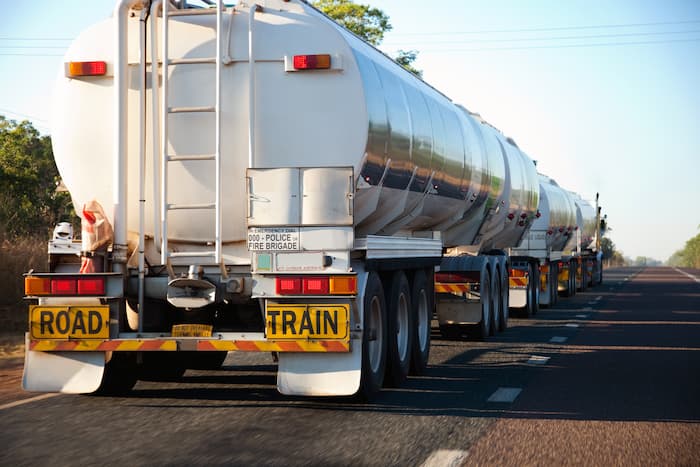 The tail end of a long lorry truck drives down a highway in the Northern Territory, Australia.