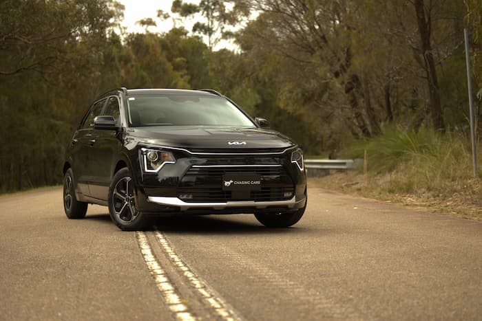 black kia niro parked across white lines on road