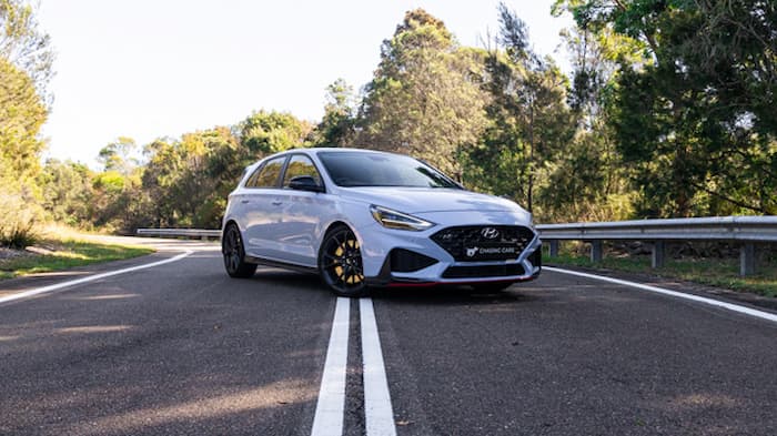 White Hyundai i30N parked across white lines on road