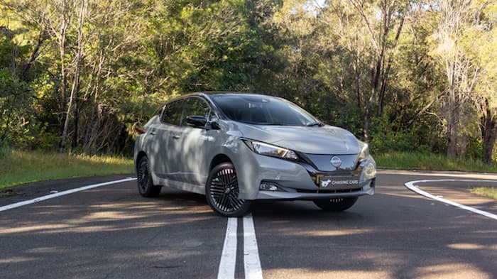 Grey colored Nissan leaf parked across white lines on road