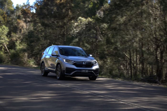   Silver honda CRV driving down road outside