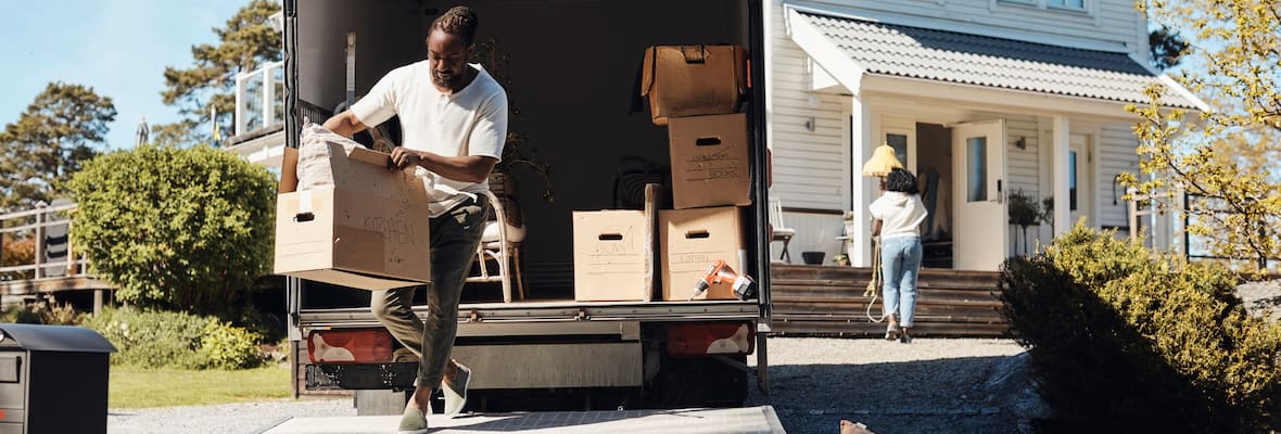 Man getting boxes out of moving van for new home