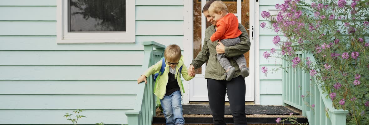 mum and two sons walk out of house down front stairs