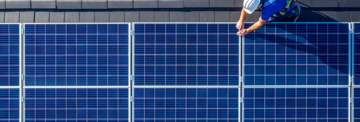 Engineer installs solar panels on modern roof