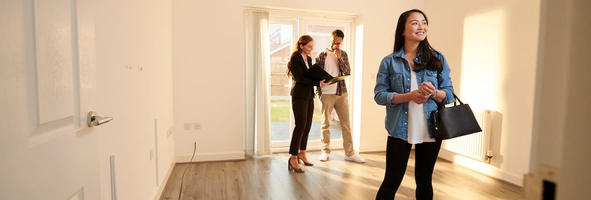 A young couple views an unfurnished rental property with their real estate agent.