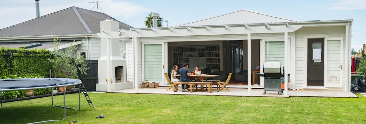 family sitting on patio in front of freshly mowed lawn