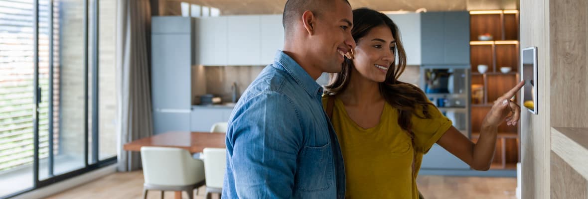 Young couple arms automated alarm system