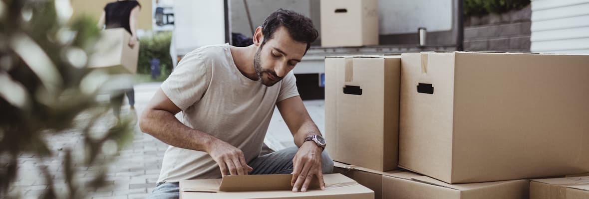 Man unpacks boxes after moving interstate