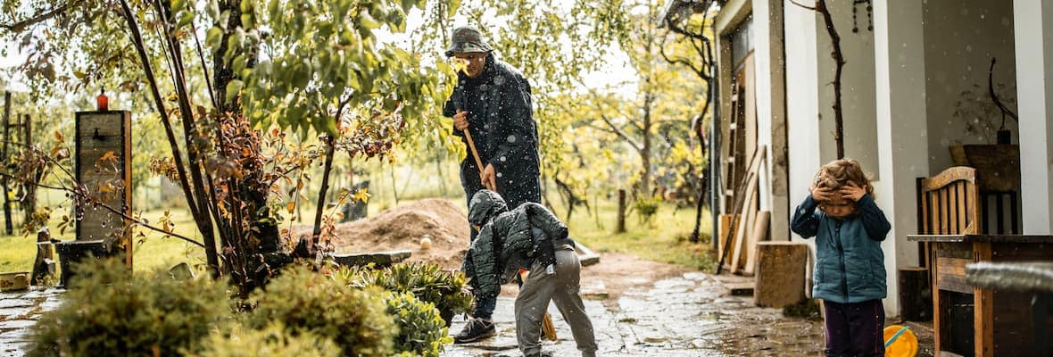 A father and son sweep water away from their home after flooding 