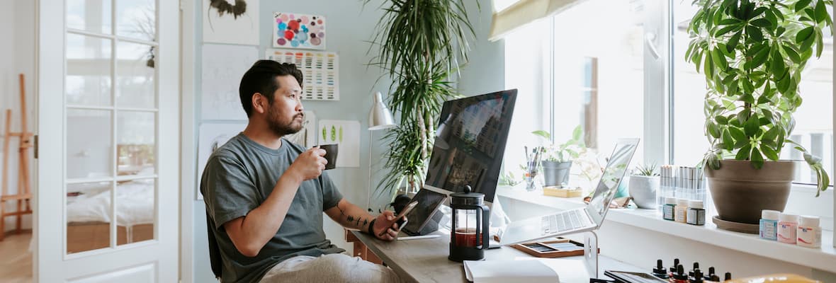 Man takes a coffee break while working from his home office